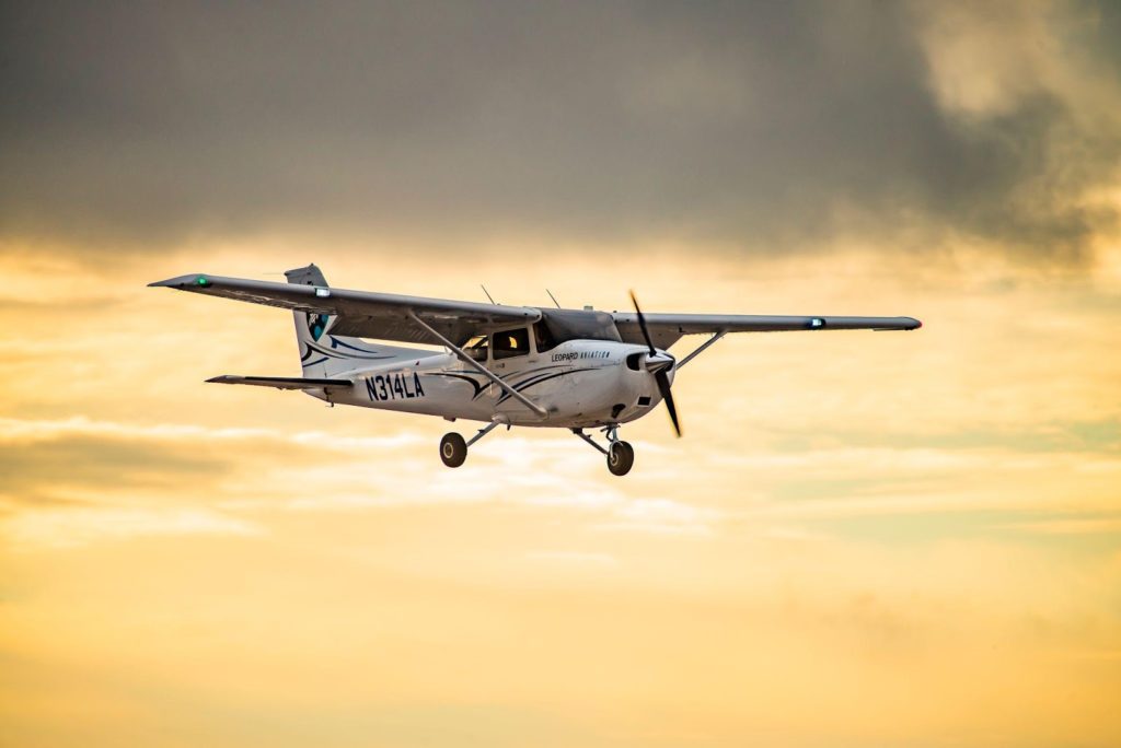 A plane flying in front of a golden sky